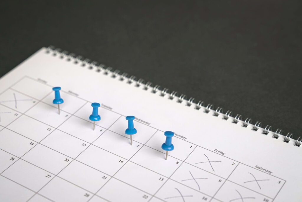 4 blue pins on a calendar