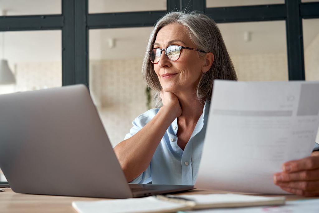 Older woman working int he office in front of the laptop